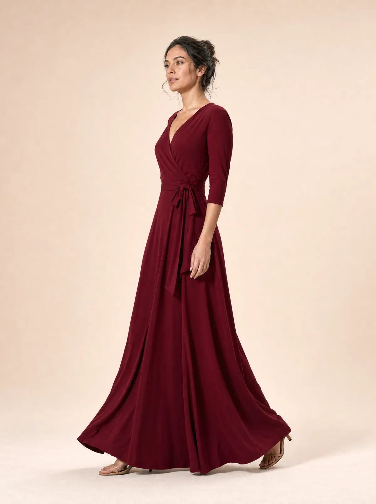 Amara burgundy wrap maxi dress in a side-profile walking view