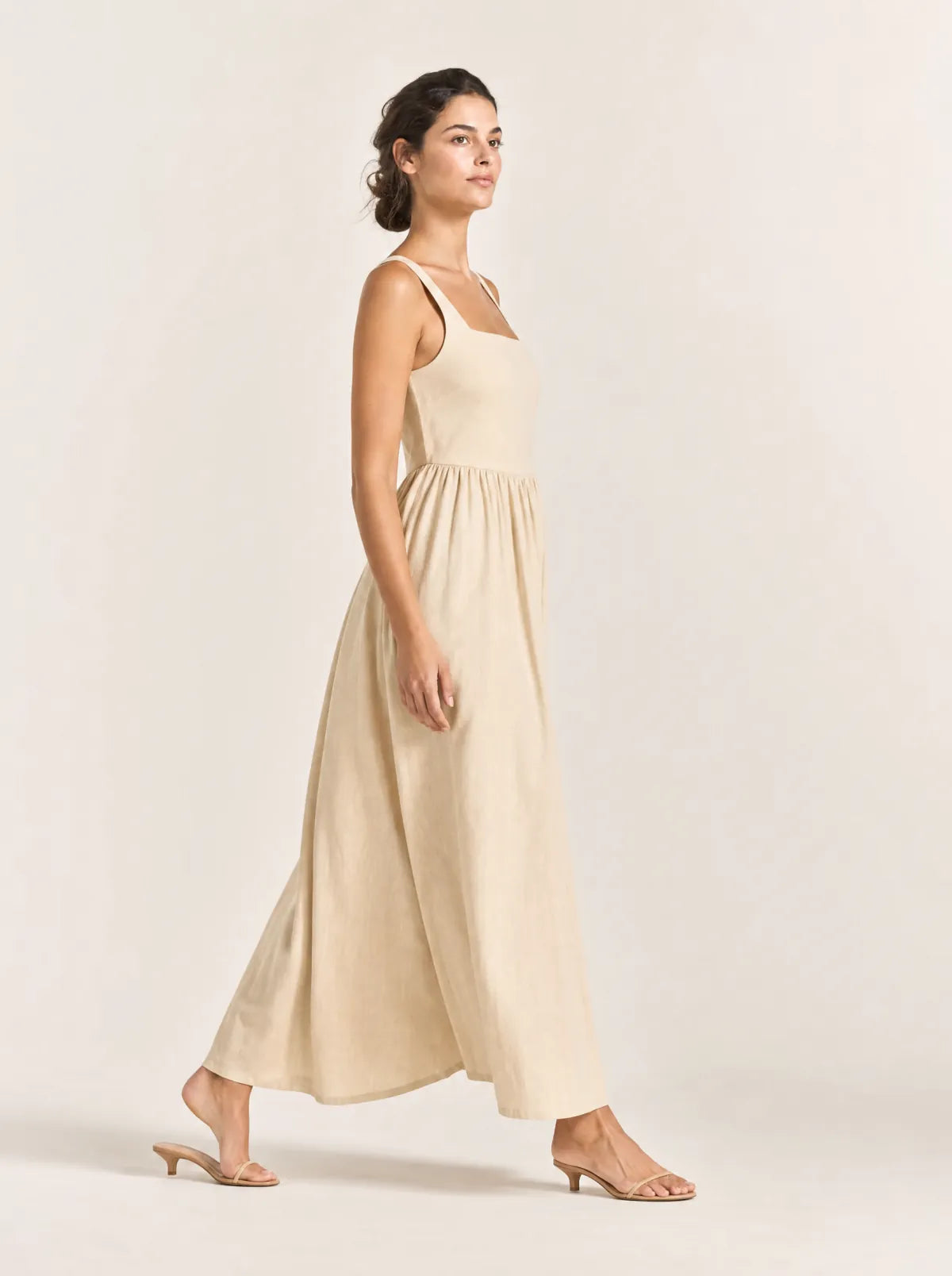 Maren sand gathered maxi dress in a side-profile walking view