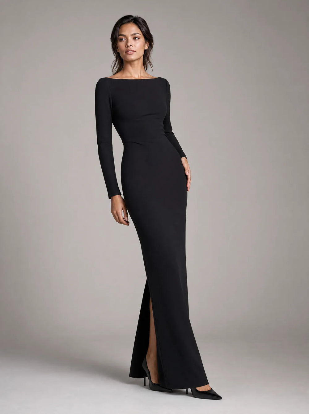 Woman wearing the black Selene long-sleeve column maxi dress against a light gray studio background